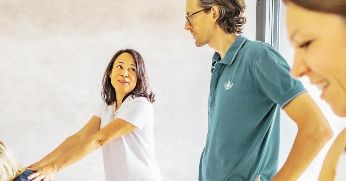 On voit la formatrice en train de guider ses stagiaires en formation massage assis.